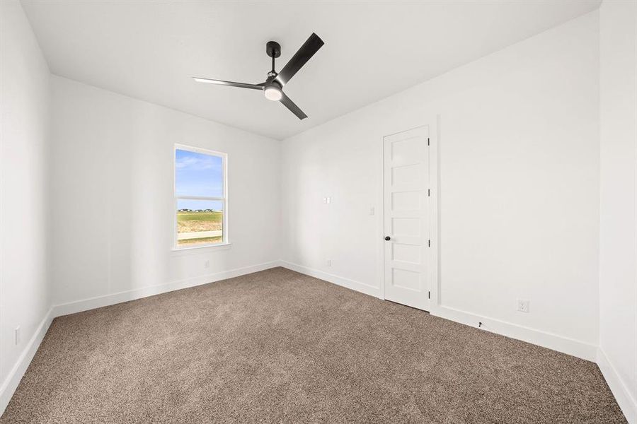 Carpeted empty room featuring baseboards and a ceiling fan Carpeted empty room featuring baseboards and a ceiling fan