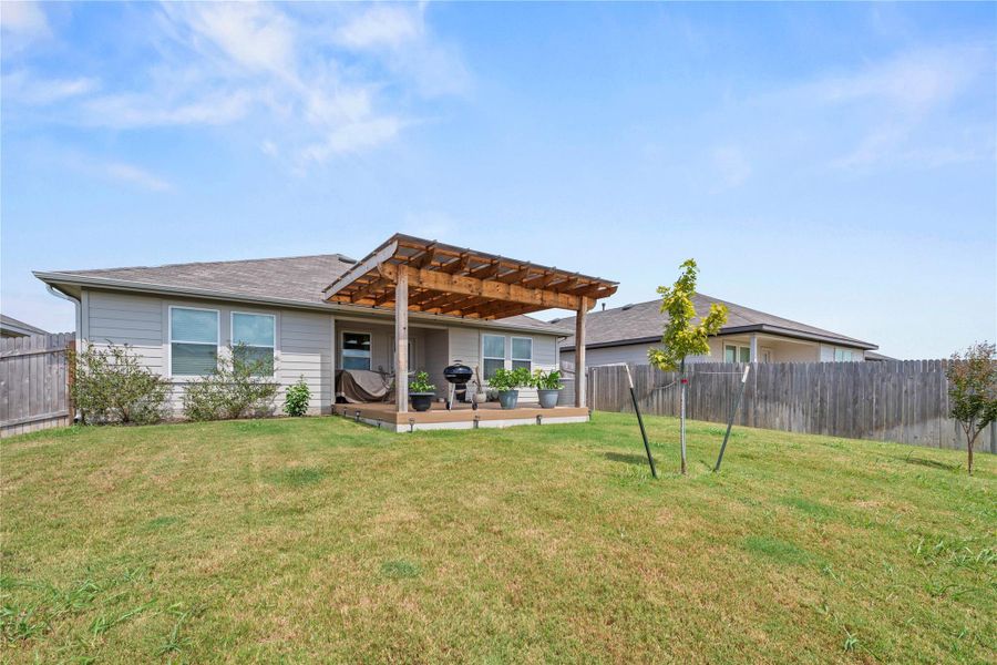 A spacious backyard features a covered patio perfect for outdoor entertaining.