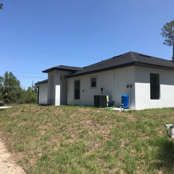 Front exterior of a new home in , Lehigh Acres, FL, highlighting curb appeal (Image 12).