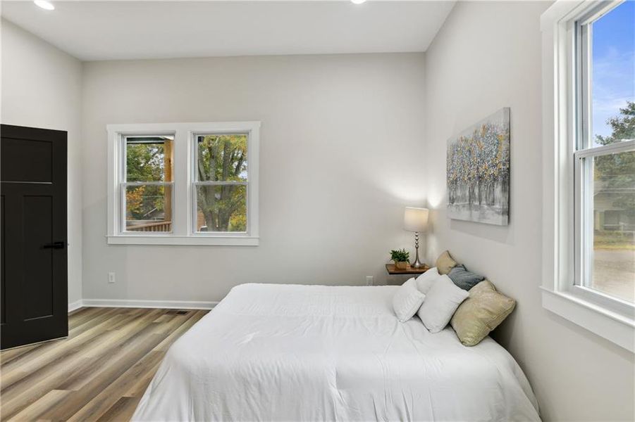 Bedroom with multiple windows and Luxury Vinyl Plank flooring