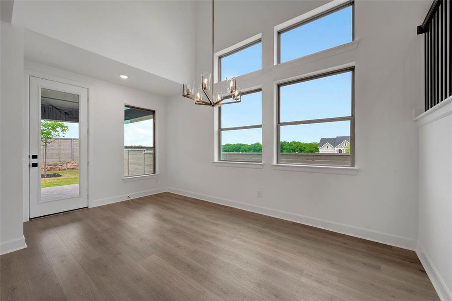 The property features high ceilings, wood plank flooring, and a modern chandelier