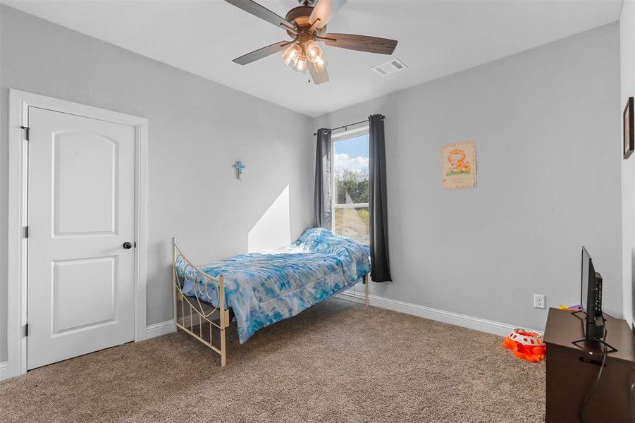 Carpeted bedroom featuring ceiling fan