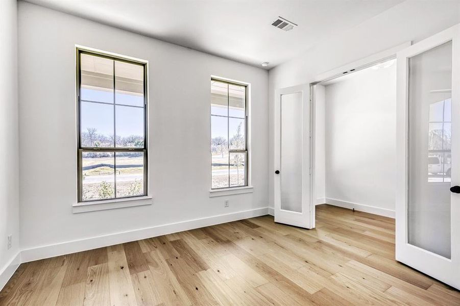 Unfurnished bedroom featuring light wood finished floors and baseboards