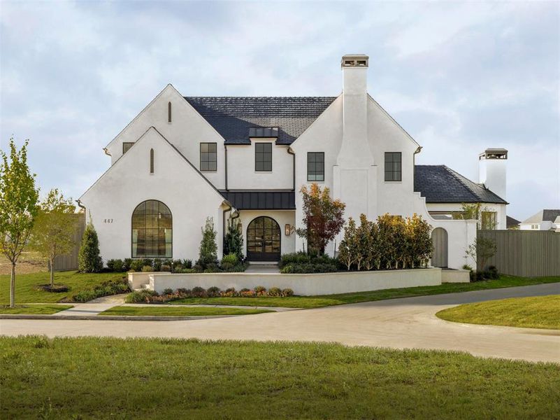 French country home with a standing seam roof, a chimney, a metal roof, and a front lawn French country home with a standing seam roof, a chimney, a metal roof, and a front lawn