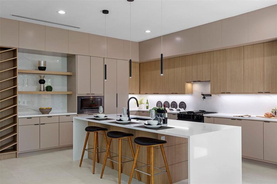 Kitchen featuring decorative light fixtures, sink, a center island with sink, gas stove, and a breakfast bar