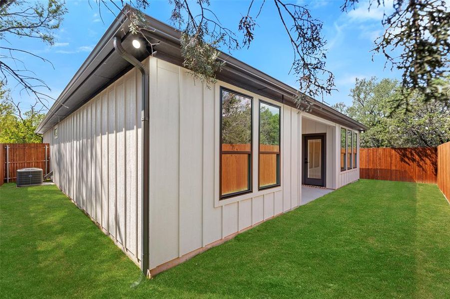 View of property exterior featuring a yard and central AC unit