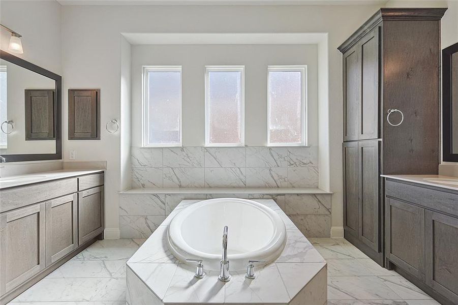 Bathroom with vanity and tiled tub