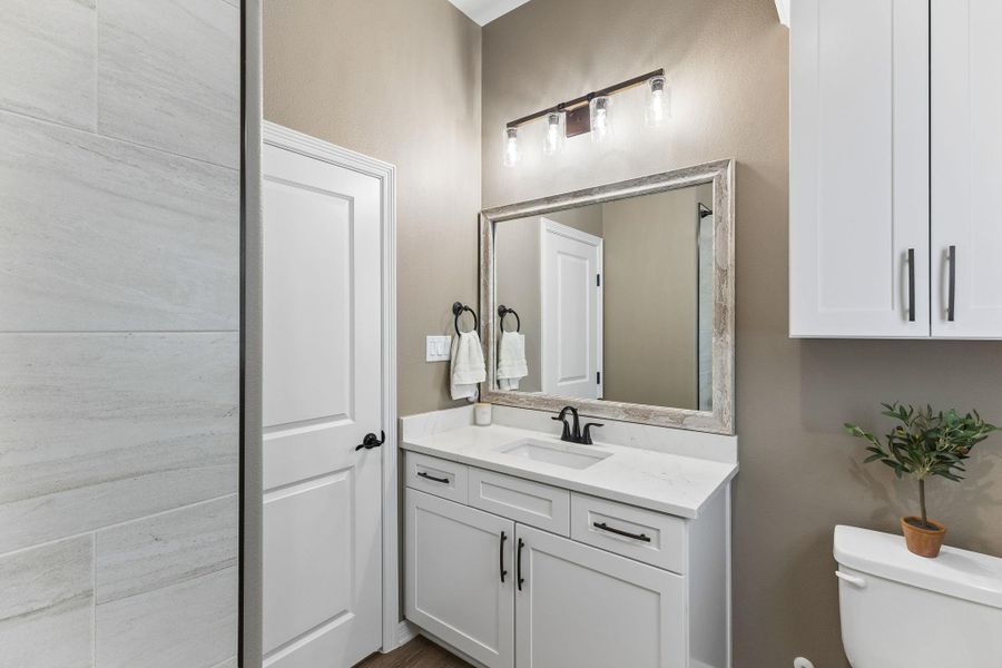 Thoughtful finishes and ample storage bring both function and style to this well-appointed secondary bath.