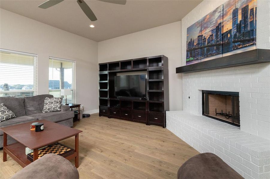 Living room featuring light wood-style floors, recessed lighting, and a fireplace