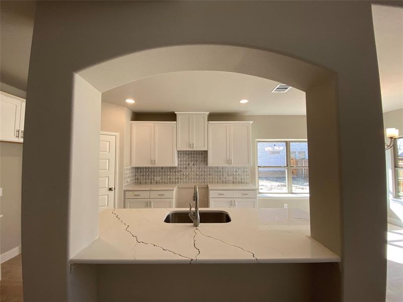 Impressive architectural eyebrow arch in kitchen.