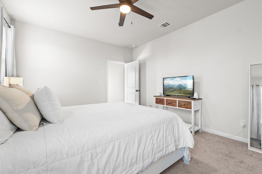 Carpeted bedroom featuring baseboards and ceiling fan Carpeted bedroom featuring baseboards and ceiling fan
