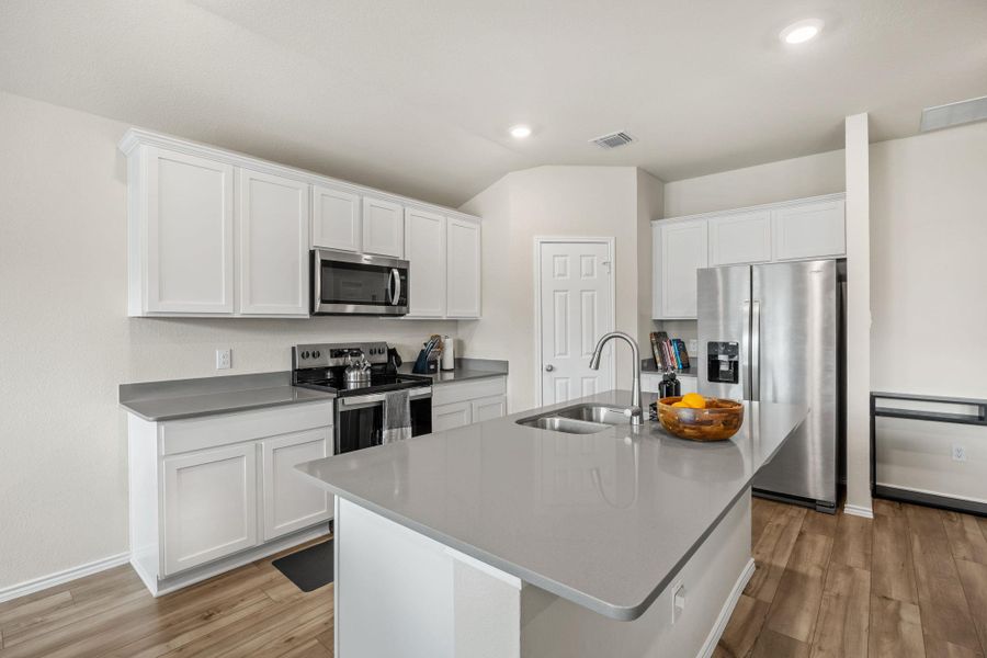 Culinary creations come to life in this modern kitchen with extensive counter space and stainless steel appliances.