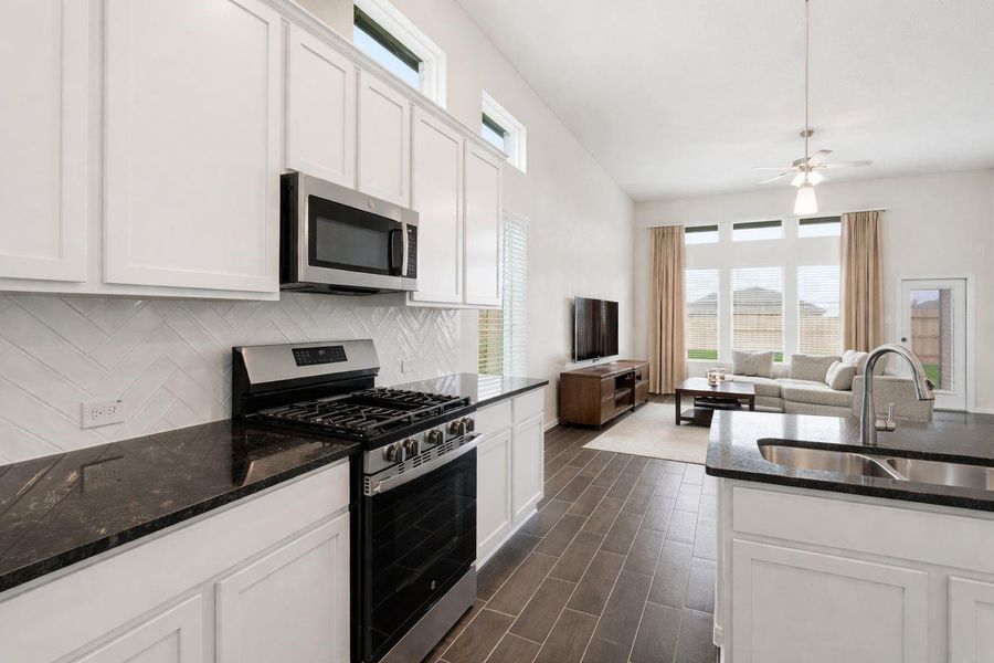 Alternate view of the kitchen highlights the gas range, sleek countertops, and generous prep space, along with a clear view into the living area, perfect for staying connected while cooking, make this home yours today! Alternate view of the kitchen highlights the gas range, sleek countertops, and generous prep space, along with a clear view into the living area, perfect for staying connected while cooking, make this home yours today!