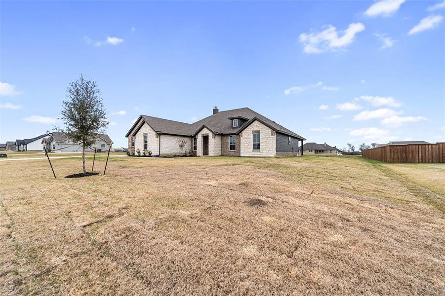 French country home with a chimney and stone siding