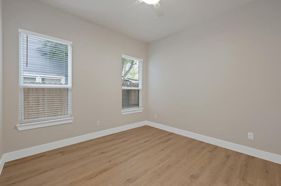 Empty room featuring light wood finished floors, baseboards, and ceiling fan Empty room featuring light wood finished floors, baseboards, and ceiling fan