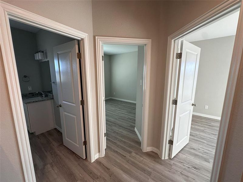 Corridor with wood-type flooring and sink