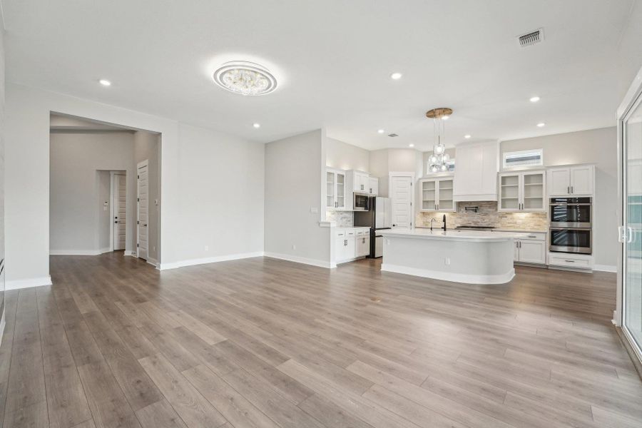 Unfurnished living room featuring recessed lighting and wood finished floors Unfurnished living room featuring recessed lighting and wood finished floors