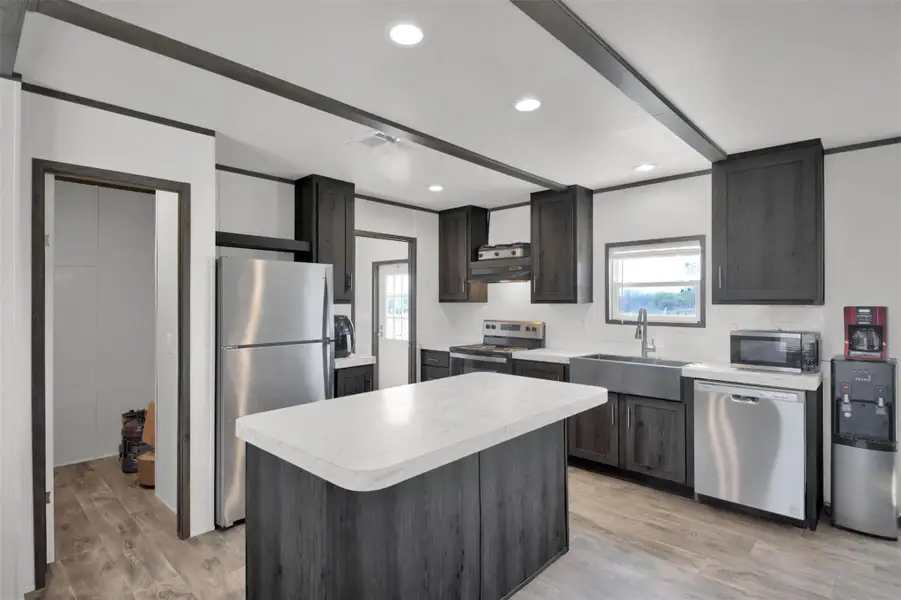 Kitchen featuring light countertops, stainless steel appliances, tasteful backsplash, light wood-style flooring, and recessed lighting