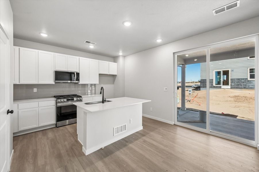 A kitchen with white cabinets.