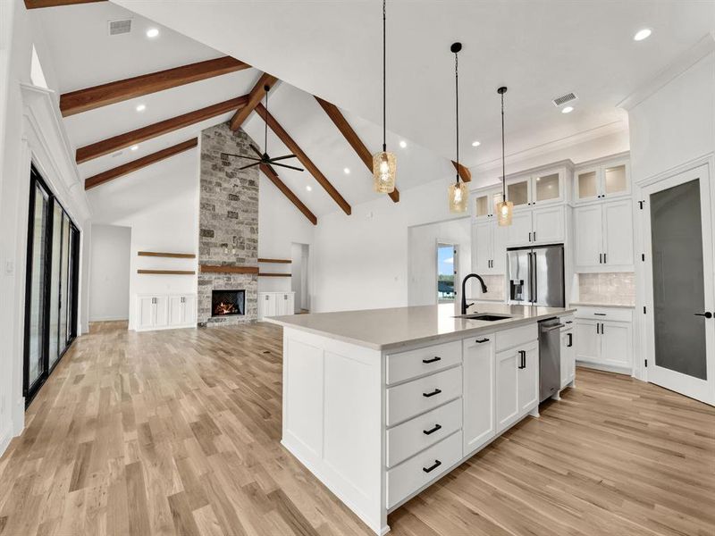 Kitchen with a sink, backsplash, light wood-type flooring, and appliances with stainless steel finishes Kitchen with a sink, backsplash, light wood-type flooring, and appliances with stainless steel finishes