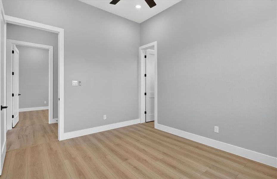 Room with vaulted ceiling, wood-finish flooring, and light gray walls