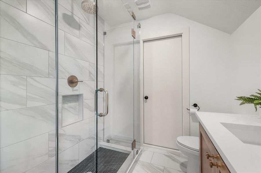 Beautiful marble tile 3 sides glass and rain shower head.  Stained vanity with quartz countertops. Man door leads to ample attic storage space.