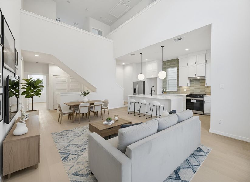 Another shot highlights the seamless flow of the living, kitchen, and dining areas, all framed by soaring 20-ft ceilings that elevate the open, modern design. *Virtually staged*