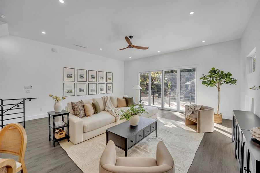 Living room with ceiling fan and hardwood / wood-style floors