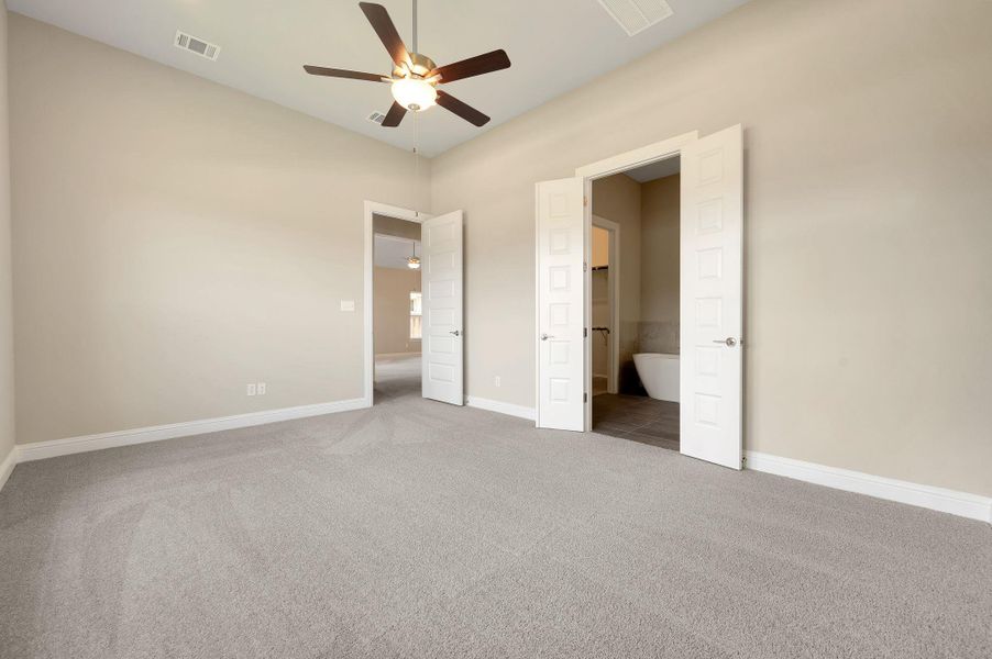 Unfurnished bedroom with carpet and a ceiling fan