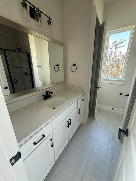 Bathroom featuring vanity, a shower stall, and light tile patterned flooring Bathroom featuring vanity, a shower stall, and light tile patterned flooring
