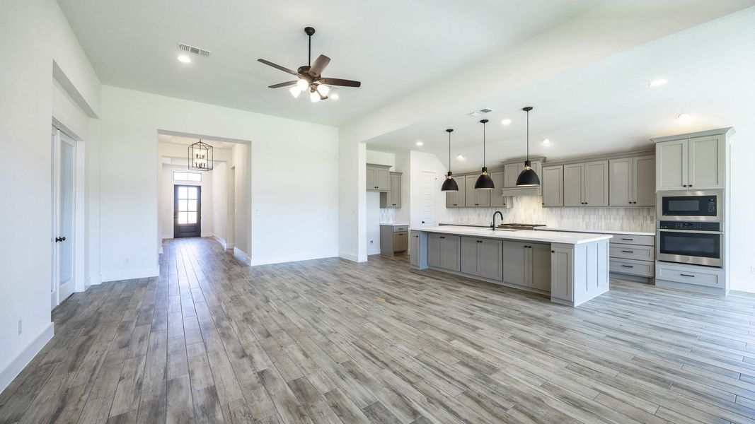 Kitchen featuring visible vents, oven, gray cabinetry, and built in microwave Kitchen featuring visible vents, oven, gray cabinetry, and built in microwave