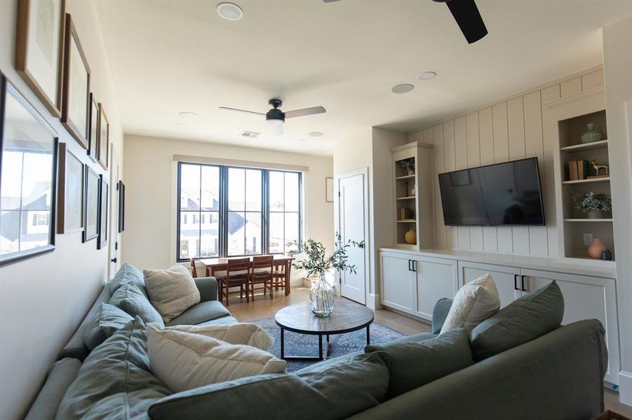 Upstairs Living room with ceiling fan, built in features, and light wood finished floors