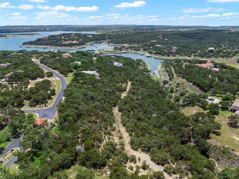 A winding road provides access to private estates nestled amongst mature trees, overlooking a serene lake. A winding road provides access to private estates nestled amongst mature trees, overlooking a serene lake.
