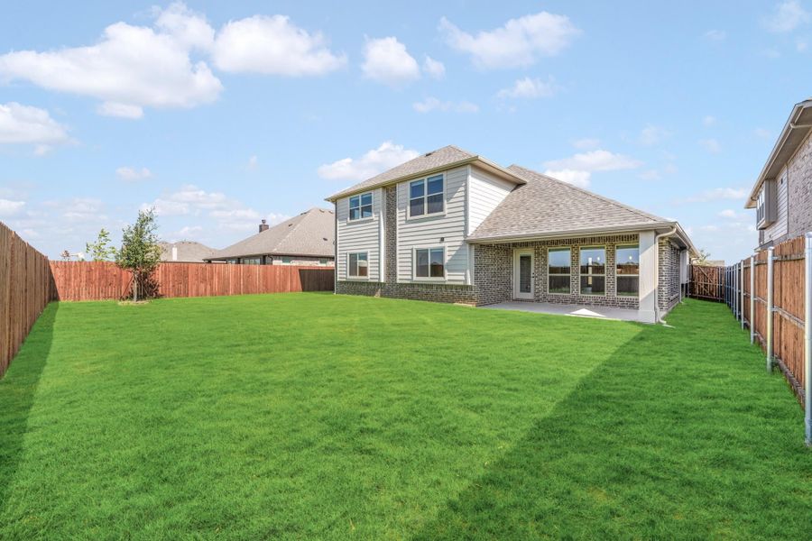 Two-story brick and siding home with large fenced backyard, covered patio, and green lawn Two-story brick and siding home with large fenced backyard, covered patio, and green lawn