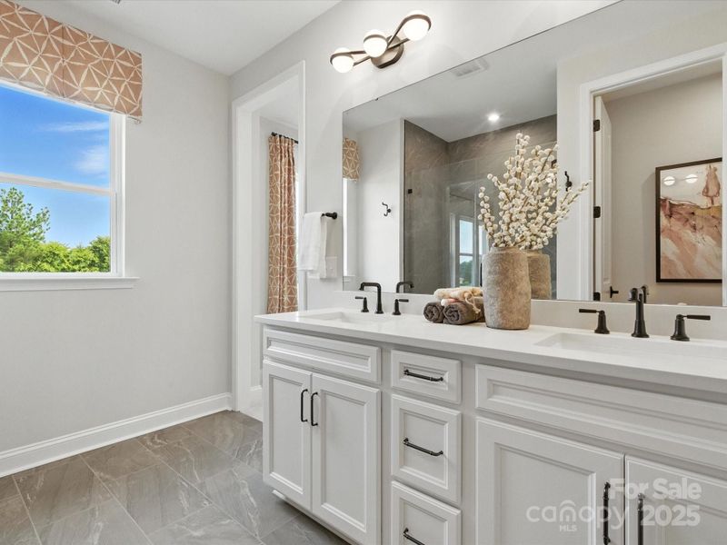 Dual vanity and bright open window takes the space to the next level. *Model Photos | Actual finishes, orientation, and structural selections may vary.