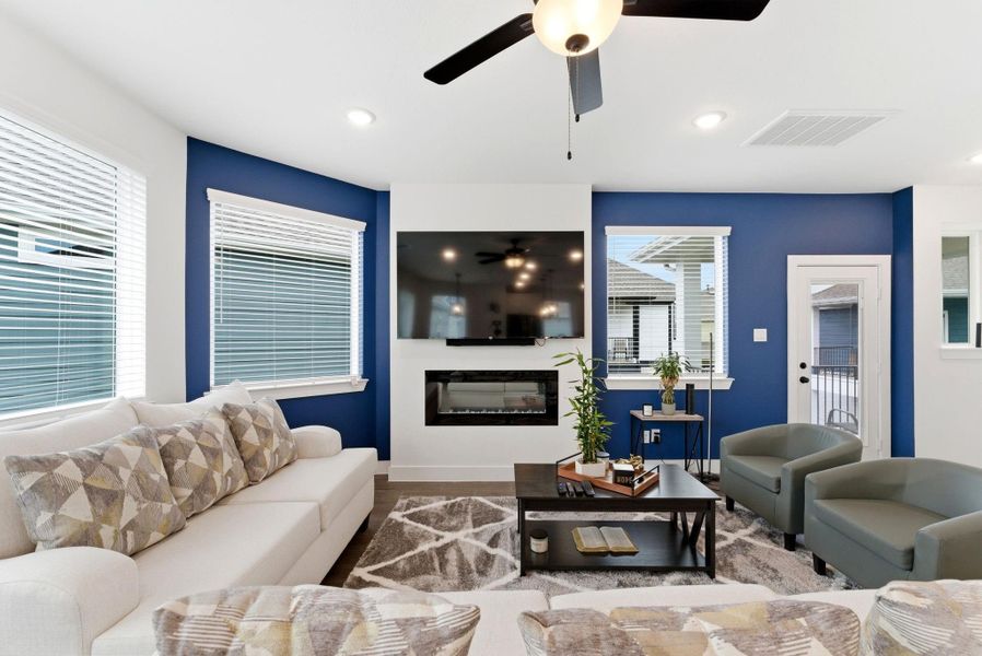 Modern living area anchored by a cozy fireplace and accent wall, perfect for movie nights or quiet evenings at home.
