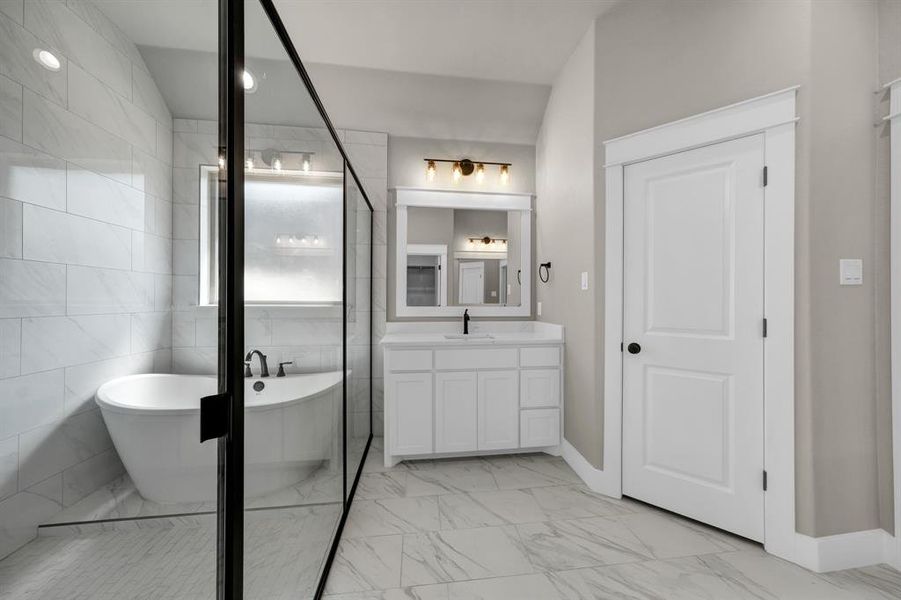 Bathroom with a tub, tile walls, tile floors, and vanity