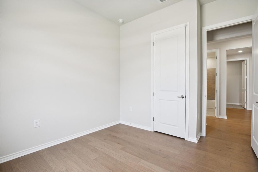 Unfurnished bedroom with light wood-style floors and baseboards Unfurnished bedroom with light wood-style floors and baseboards
