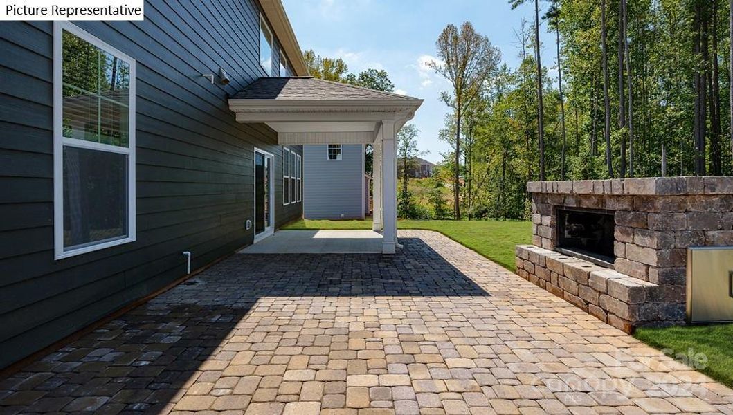 Rear of home with covered porch, & paver patio w/fireplace - Sample picture.