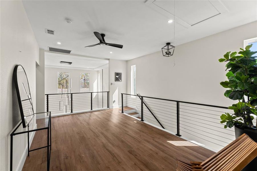 Corridor with an upstairs landing, dark wood-type flooring, and recessed lighting