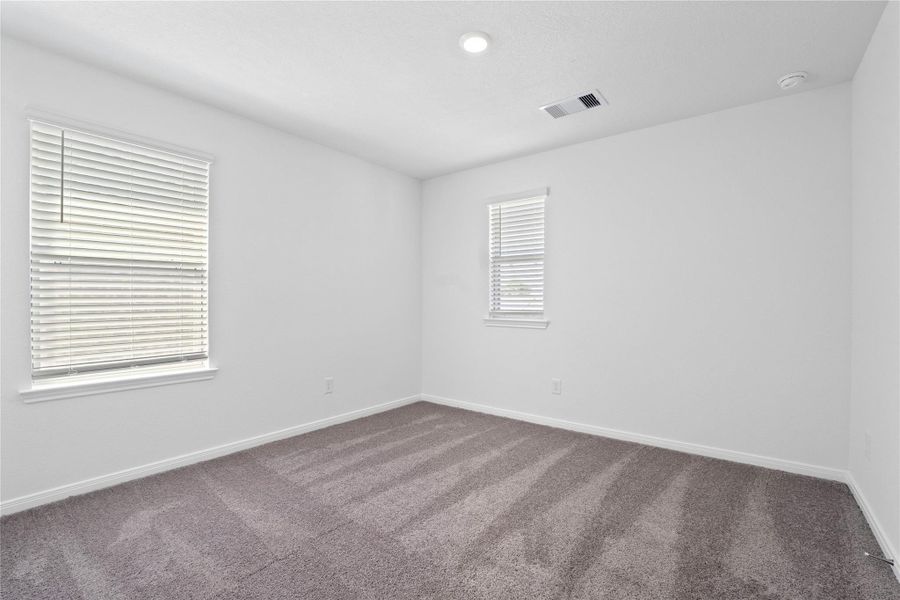 This secondary bedroom offers comfort and style with plush carpeting, neutral paint tones, recessed lighting, windows with blinds, and a generously sized closet. This secondary bedroom offers comfort and style with plush carpeting, neutral paint tones, recessed lighting, windows with blinds, and a generously sized closet.