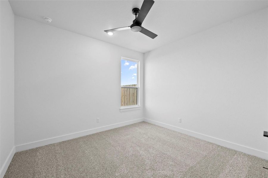 Carpeted spare room with baseboards and a ceiling fan Carpeted spare room with baseboards and a ceiling fan