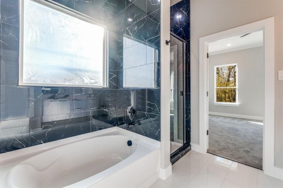 Full bathroom with a garden tub, ornamental molding, a marble finish shower, and carpet flooring