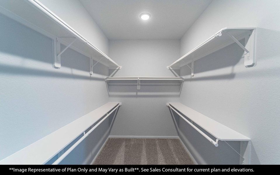 Primary bedroom walk-in closet offering generous space for clothing, shoes, and personal belongings. Designed with comfort and convenience in mind, featuring soft carpet flooring and bright recessed lighting to keep everything easy to see and access. **Image Representative of Plan Only and May Vary as Built**.