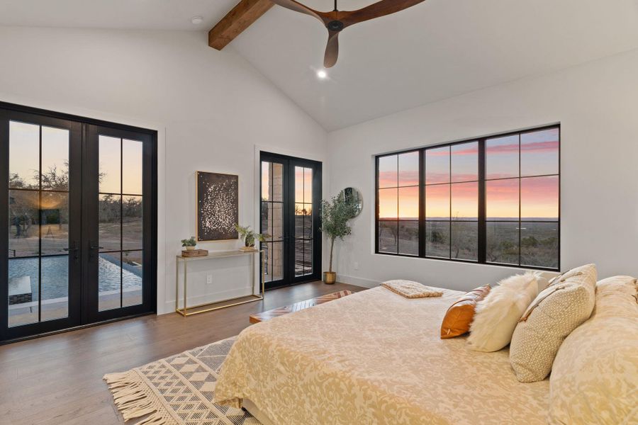 Primary bedroom with french doors, access to outside, wood finished floors, ceiling fan, and recessed lighting and views for miles.