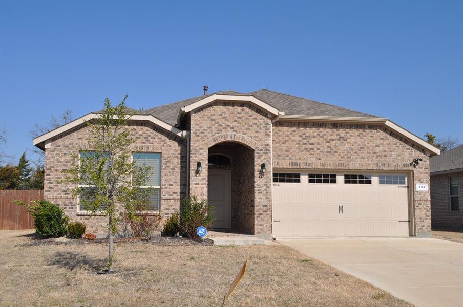 View of front facade with a garage and a front lawn