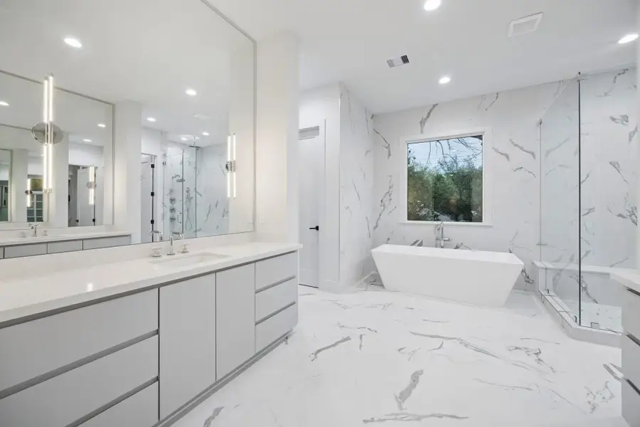 rimary Bath with Dual Counters, Inset Cabinetry, Frameless Mirrors, Pendent Lighting, Freestanding Soaking Tub with a Floor Mounted Tub Filler.