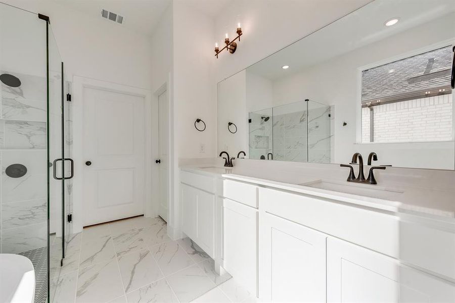 Bathroom with a marble finish shower, light marble finish floors, double vanity, and recessed lighting Bathroom with a marble finish shower, light marble finish floors, double vanity, and recessed lighting