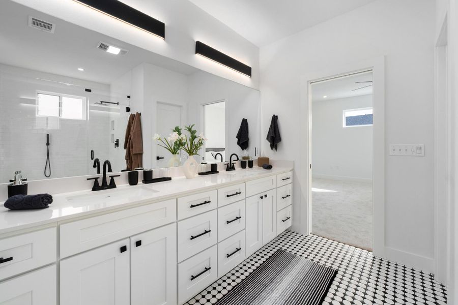 Bathroom featuring double vanity, a stall shower, and light colored carpet