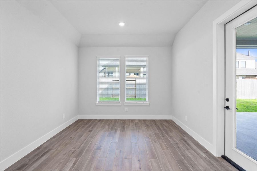 Create lasting memories around the table with family and friends in the dining! It showcases sloped ceilings, large windows with fitted blinds, tile flooring, and recessed lighting for a warm and welcoming atmosphere. Access door to the rear covered patio and backyard green space.